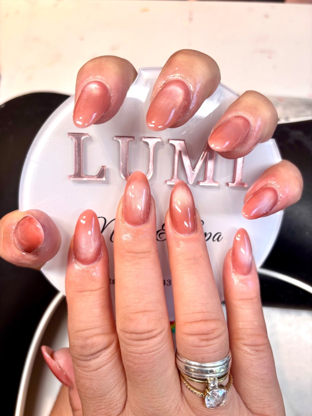 Glanzende perzikroze nagels met cat-eye effect