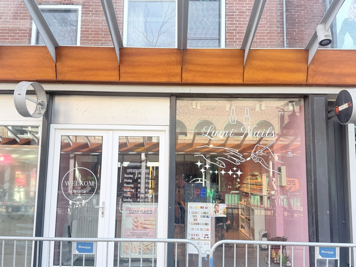 Gevel van Lumi Nails Studio & Spa aan de Lange Nering in Emmeloord, met de naam in het raam, de openingsstijden en een OPEN-verlichting