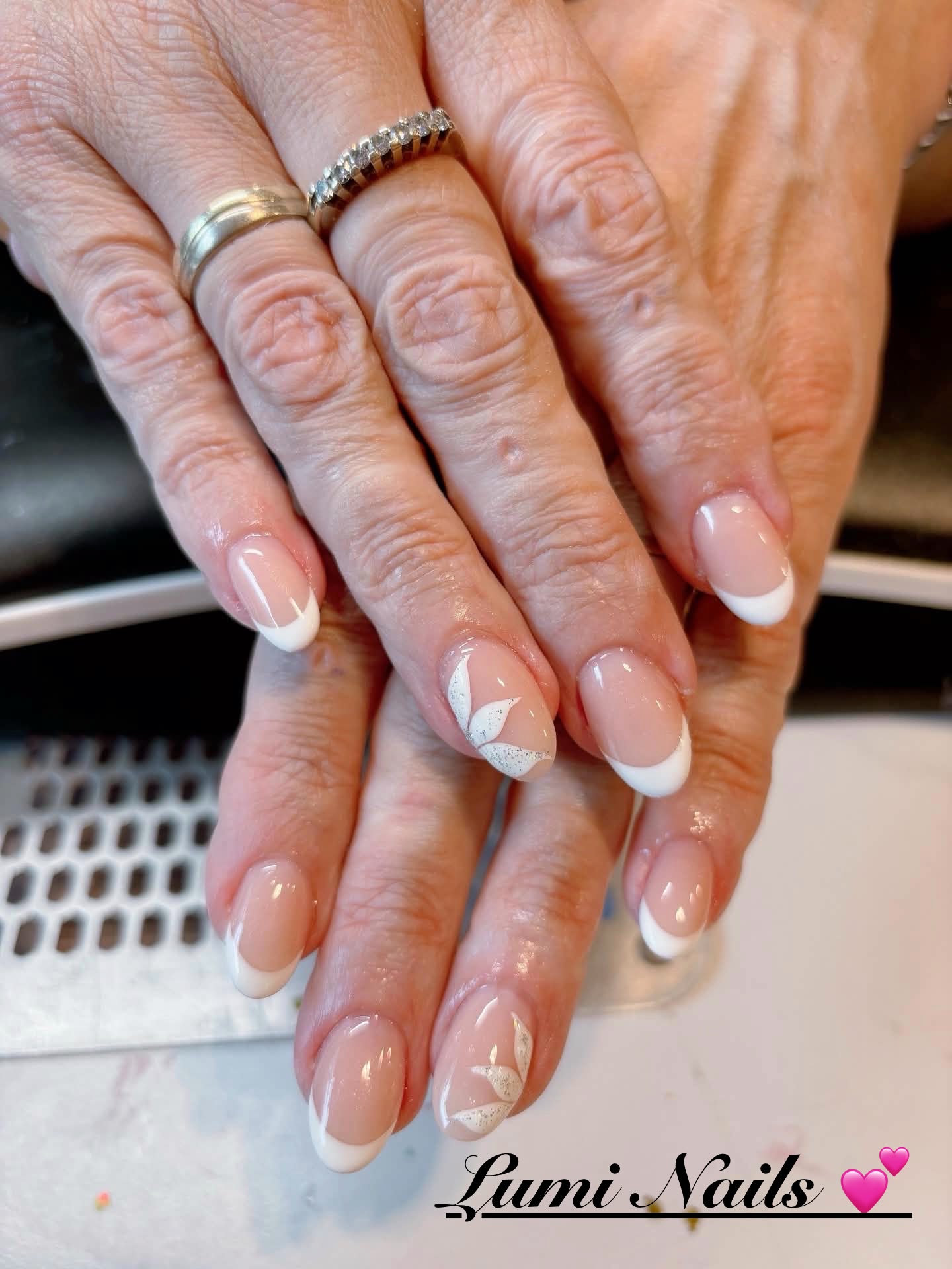 Klassieke witte french manicure met zilveren glitterbloemen