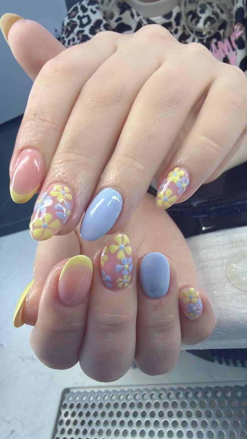 Pastelblauwe nagels met gele French tips en beschilderde bloemen
