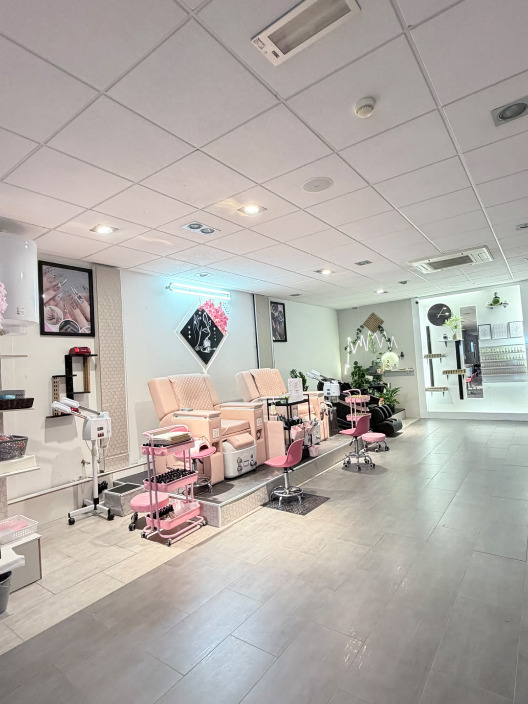 Pedicurehoek met twee roze massagestoelen en ingebouwde voetenbaden