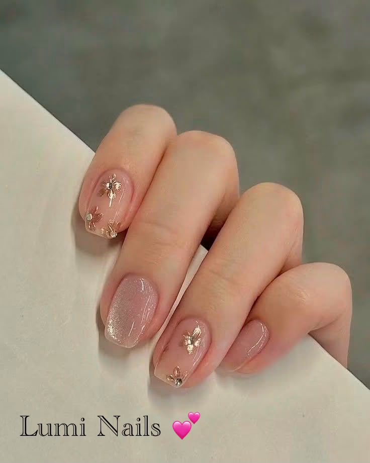 Nude nagels met metallic bloemen en glinsterende steentjes